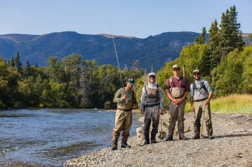 A group of four anglers stand in a line to get their picture taken before starting the Alaskan fishing season.